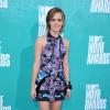 Emma Watson apostou em um vestido curtinho estampado da grife Brood. Ela usou acessórios rockers para compor o look do MTV Movie Awards 2012