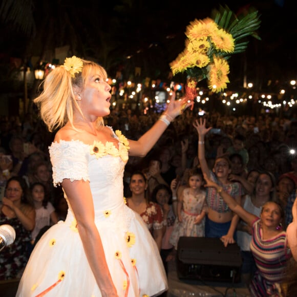 Deborah Secco, com look de noiva, joga buquê parao público presente no evento