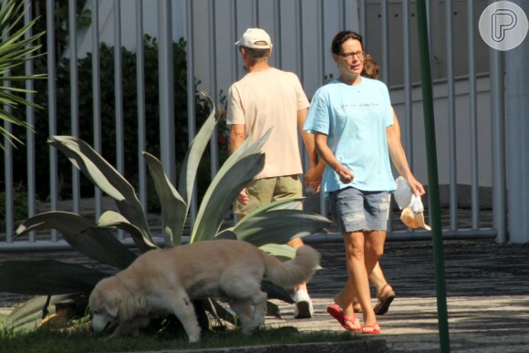 De bermudão, Carolina Ferraz leva cachorro para passear no Rio neste sábado, 29 de março de 2014