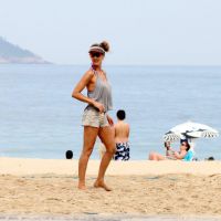 Fernanda Lima desfila para fotógrafo durante partida de vôlei na praia