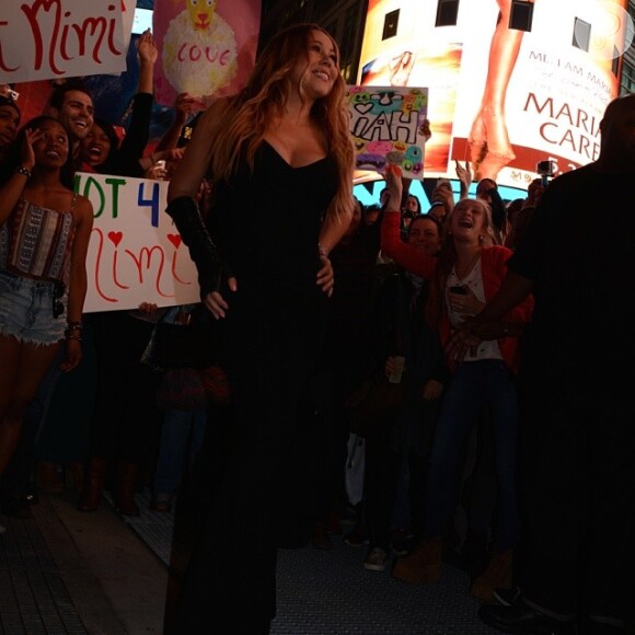 Mariah Carey observa a capa de seu Cd sendo exibida na Times Square, em Nova York