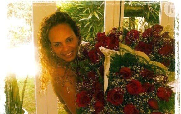 Paola de Luca no dia de seu aniversário, com três buquês de rosas vermelhas