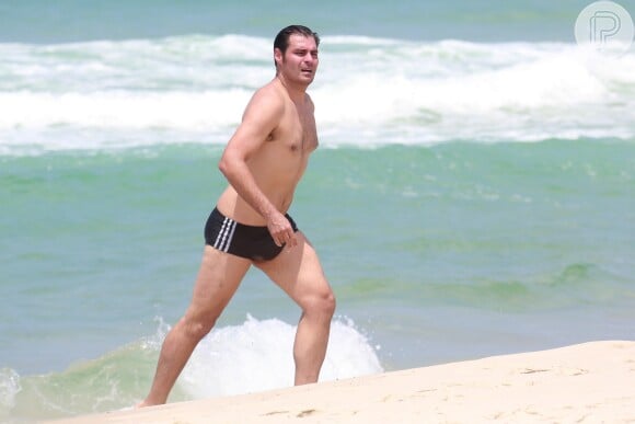 Thiago Lacerda aproveitou o dia de sol e deu um mergulho após o treino na praia