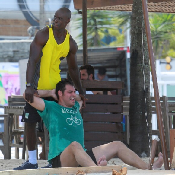 Thiago Lacerda se alonga após exercício com ajuda do seu instrutor