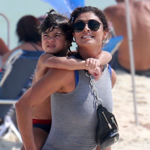 Juliana Paes deixou a praia com o filho caçula, Antônio, na garupa