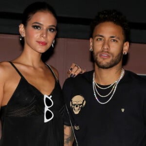 Bruna Marquezine investiu em um vestido curto preto com toque de transparência e botas over the knee de látex para a festa de Rafaella Santos