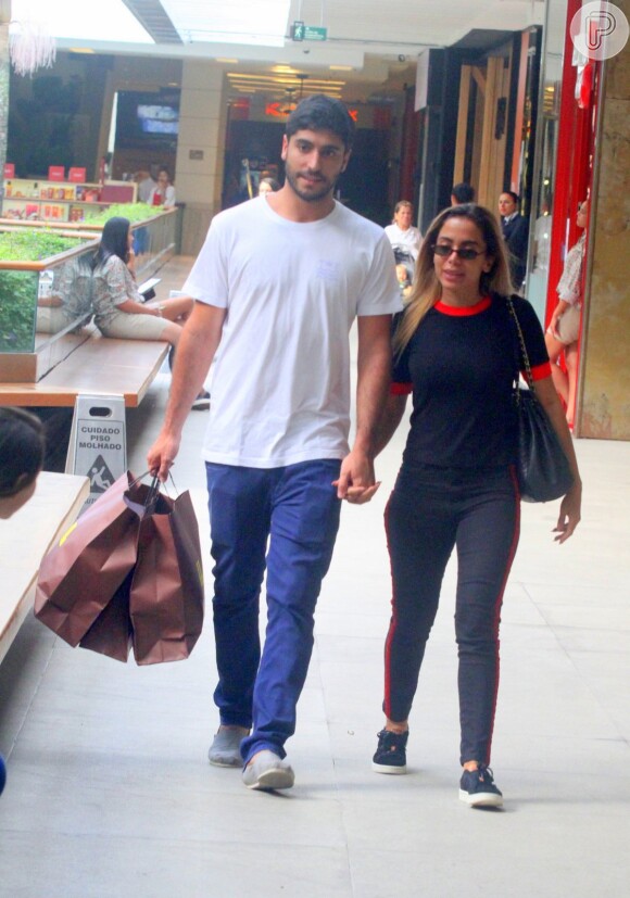 Anitta e o marido, Thiago Magalhães, caminham de mãos dadas no shopping Fashion Mall, em São Conrado