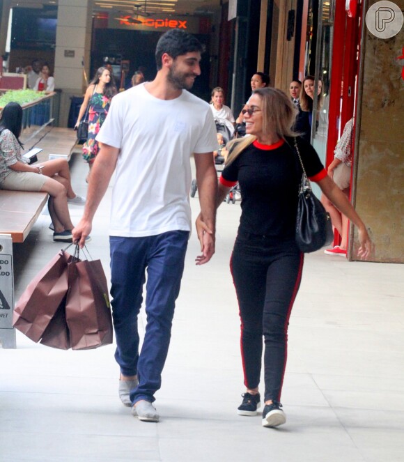 Anitta e o marido, Thiago Magalhães, conversam enquanto caminham no shopping
