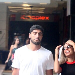 Anitta e o marido, Thiago Magalhães, conversam enquanto caminham no shopping