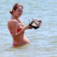 Candice Swanepoel deixou o  barrigão de grávida em evidência na praia 