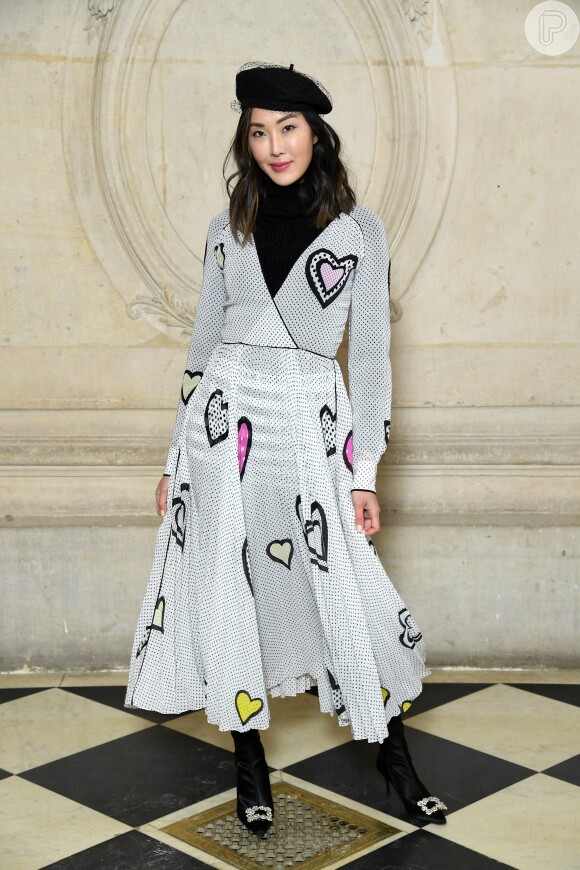 A blogueira Chriselle Lim usou vestido com detalhes de corações, boina e botas com fivela de strass no desfile da coleção outono/inverno 2018-2019 de Christian Dior na Paris Fashion Week, na França, em 27 de fevereiro de 2018