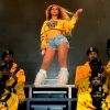 Beyoncé usou também produção mais descolada e com tema colegial: um moletom amarelo, short jeans e bota de franja holográfica por Christian Louboutin