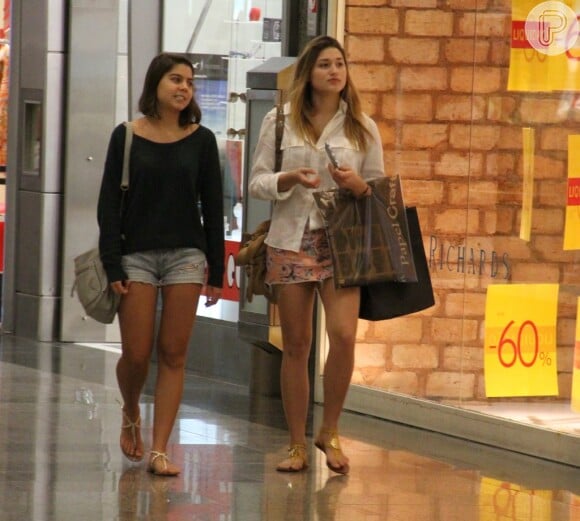 Sasha conversa com a amiga enquanto passeia pelo shopping