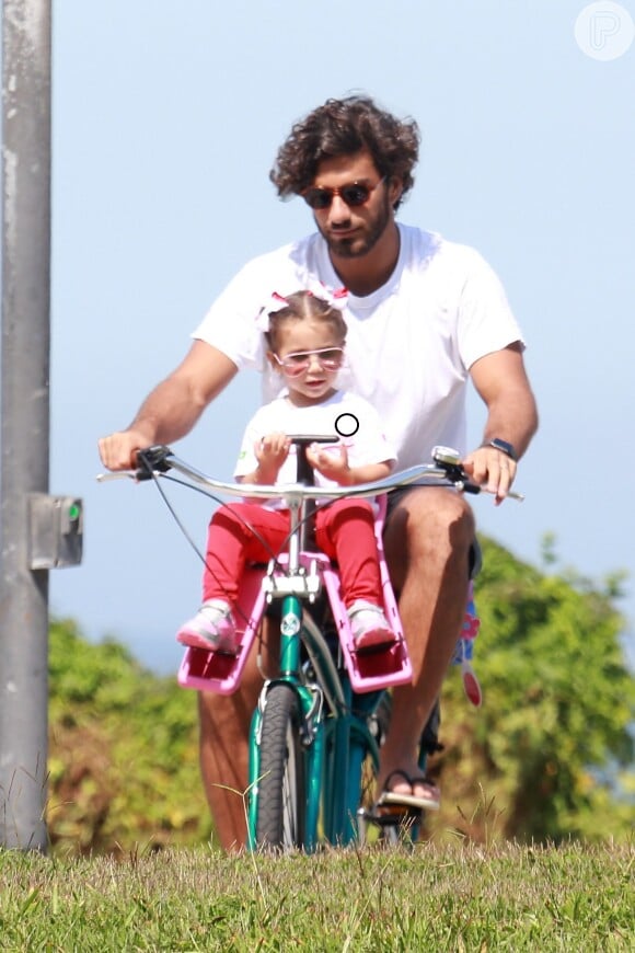 Maria Flor conversa com o pai, Hugo Moura, durante passeio de bicicleta