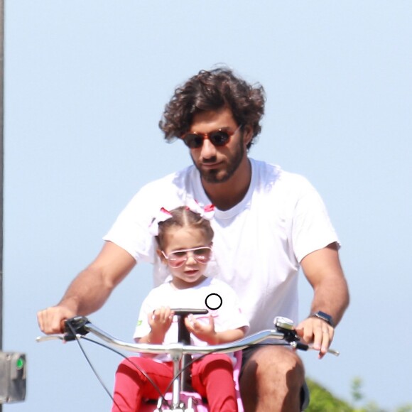 Maria Flor conversa com o pai, Hugo Moura, durante passeio de bicicleta