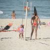 Deborah Secco toma ducha na praia da Barra da Tijuca com a filha, Maria Flor, por perto