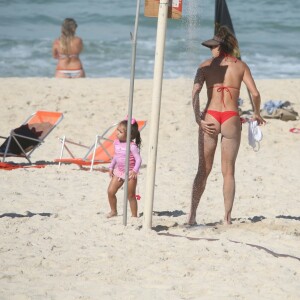 Deborah Secco toma ducha na praia da Barra da Tijuca com a filha, Maria Flor, por perto