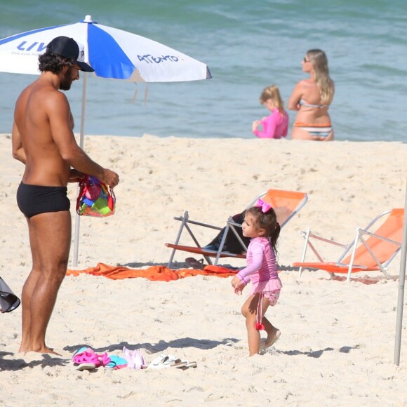 Hugo Moura conversa com a filha, Maria Flor, observado pela mulher, Deborah Secco