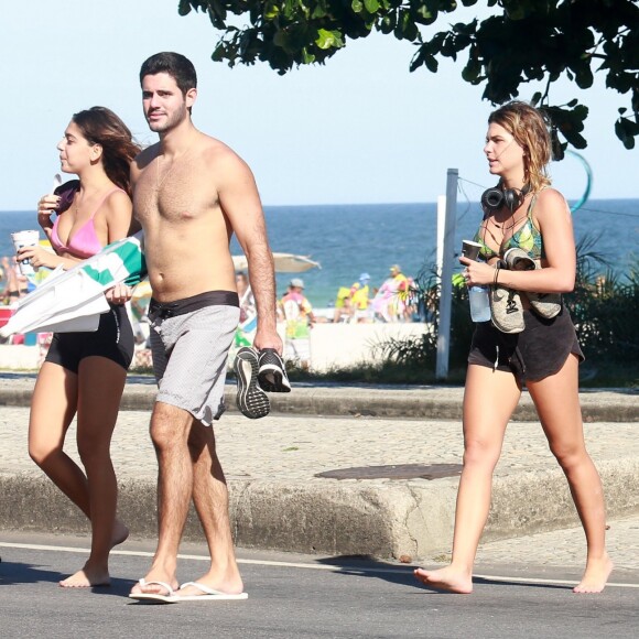 Namorada de Cauã Reymond, Mariana Goldfarb caminha com amigos na praia da Barra da Tijuca