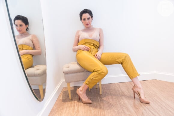 Fernanda Vasconcellos aposta no look com camisa segunda pele de tule com a lingerie à mostra branca e calça cintura alta amarela ocre, de R$ 4390, da 'Nkstore'