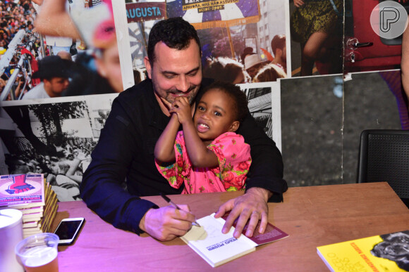 Julia, filha de Leandra Leal e Ale Youssef, ficou no colo do pai durante parte da noite de autógrafos