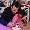 Julia, filha de Leandra Leal e Ale Youssef, 'ajuda' o pai a dar autógrafo em livro