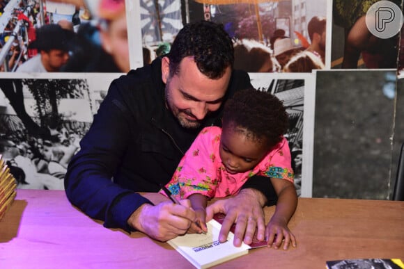 Julia, filha de Leandra Leal e Ale Youssef, 'ajuda' o pai a dar autógrafo em livro