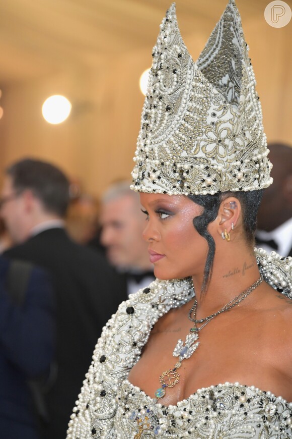 As joias escolhidas por Rihanna para o Met Gala completaram o ar 'divino' da produção: um cordão com uma pomba cravejada de diamantes e com crucifixo