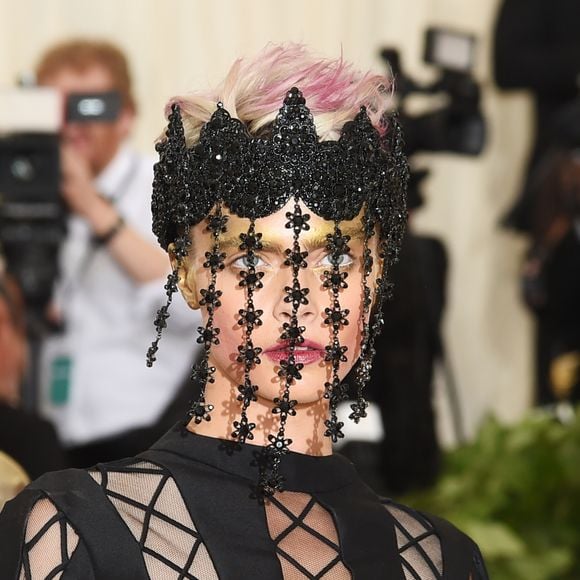 Cara Delevingne apostou em uma maquiagem brilhante composta por batom escarlate e sombra amarela nos olhos
