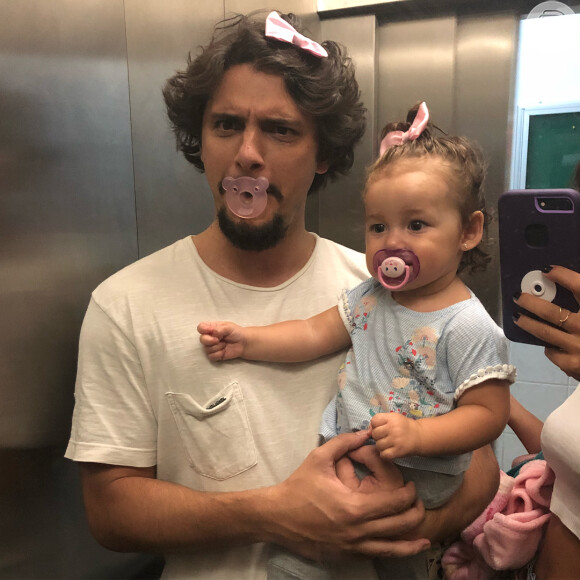 Bruno Gissoni divertiu os internautas neste sábado, 12 de maio de 2018, ao publicar uma foto usando chupeta e lacinho cor-de-rosa, assim como sua filha, Madalena