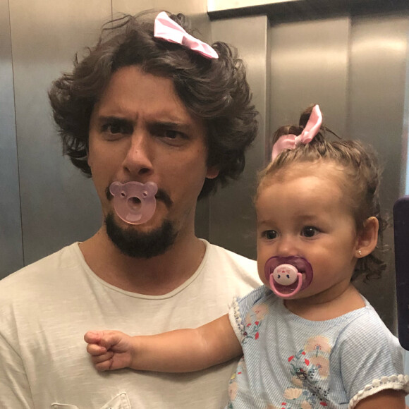 Bruno Gissoni divertiu os internautas neste sábado, 12 de maio de 2018, ao publicar uma foto usando chupeta e lacinho cor-de-rosa, assim como sua filha, Madalena