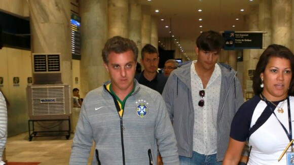 Luciano Huck e Ashton Kutcher desembarcam em aeroporto do Rio e são fotografados