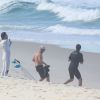 Rodrigo Santoro se alongou na areia antes de entrar no mar para surfar