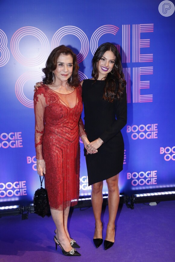 Beth Faria, em um vestido vermelho com transparências, foi recebida por Isis Valverde na festa de lançamento da novela 'Boogie Oogie'