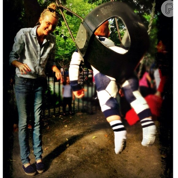 Carol Trentini brinca com seu herdeiro, Bento, em um balanço de parque infantil em Nova York