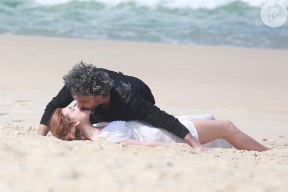 Maria Isis (Marina Ruy Barbosa) e José Alfredo (Alexandre Nero) rolam da areia de praia em cenas ousadas