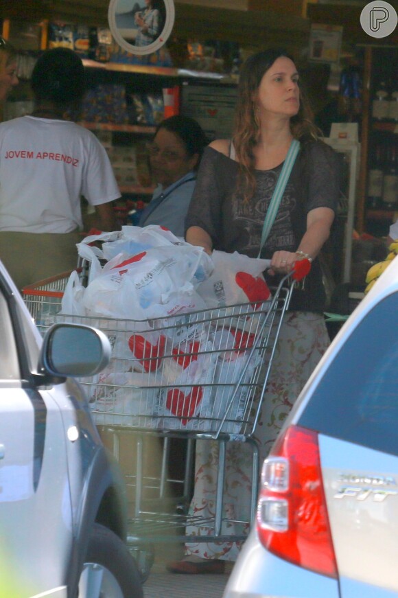 Vanessa Lóes leva o carrinho de compras até o carro
