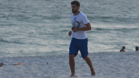 Cauã Reymond posa sorridente com fãs após correr na praia