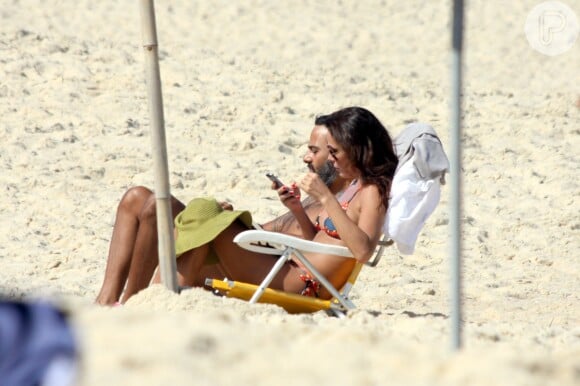 Carolina Ferraz e o namorado, Marcelo Marins, relaxam na praia do Leblon, na Zona Sul do Rio de Janeiro