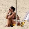Carolina Ferraz coloca o bronzeado em dia em praia carioca