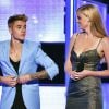 Justin Bieber se apresentou de casaco, mas resolveu tirar a peça ao lado da modelo Laura Stone