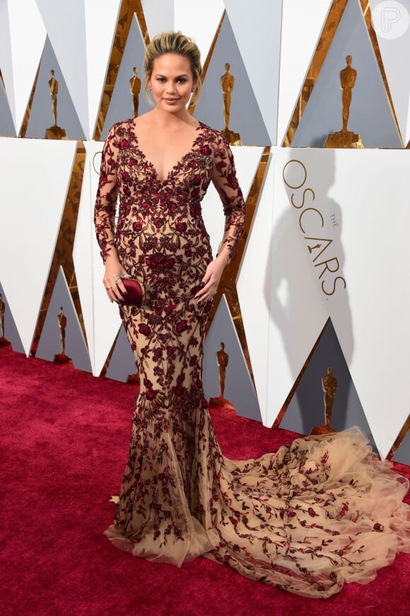 Chrissy Teigen, estava grávida da primeira filha, Luna, na 88ª edição do Oscar, em 2016. Para a cerimônia, a apresentadora apostou em um vestido nude com bordados vermelhos da grife Marchesa.