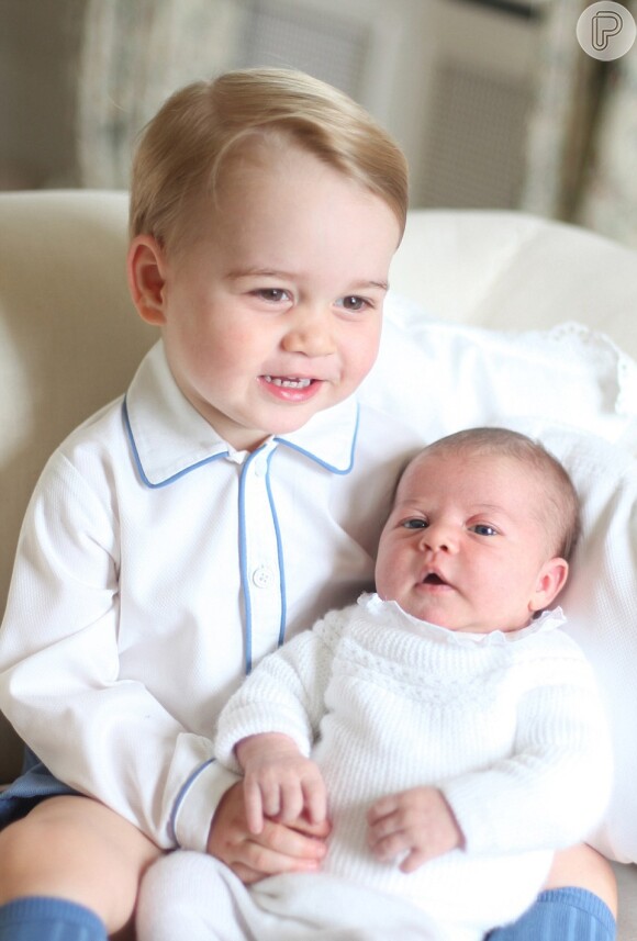 Arrasando corações: Charlotte apareceu em sua primeira foto oficial no colo do irmão, George. As imagens da fofa dupla foram divulgadas pelo Palácio de Kensington.