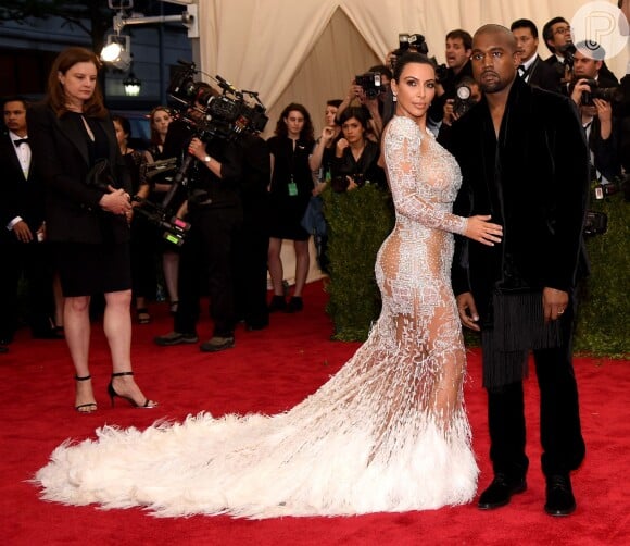 Kim Kardashian passou pelo tapete vermelho do MET Gala 2015 ao lado do marido, Kanye West. A empresária usou a primeira criação de Peter Dundas para a grife Roberto Cavalli. O vestido, além de muita transparência, contava com uma cauda de penas e bordados.