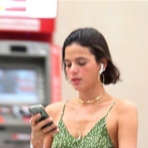 Bruna Marquezine aposta em vestido fluído verde e usa jaqueta amarrada na cintura ao desembarcar em aeroporto