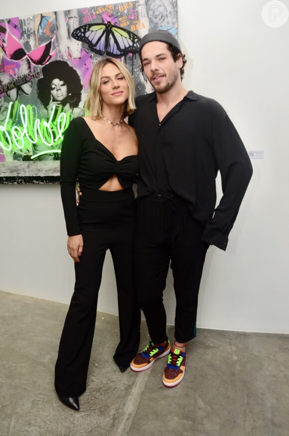 Giovanna Ewbank posou abraçada ao irmão, Gian Luca, na inauguração da exposição dele em São Paulo