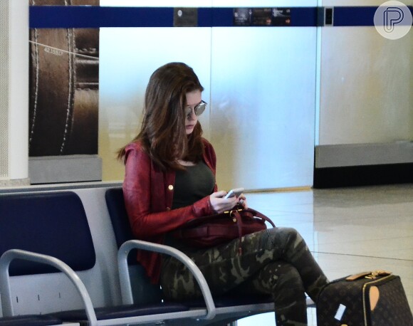 Antes do embarque, Marina Ruy Barbosa conferiu mensagens de seu smartphone