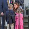 Kate Middleton, grávida de quatro meses, conversa com duas crianças em Londres