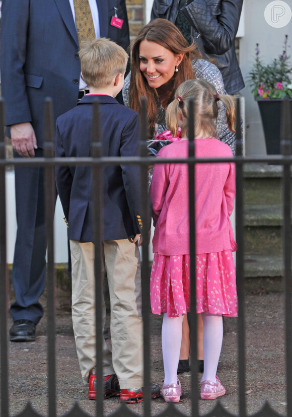 Kate Middleton, grávida de quatro meses, conversa com duas crianças em Londres