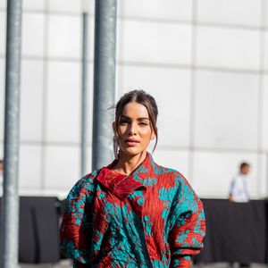 Camila Coelho de look curtinho e estampado (repare na bolsa neon) na porta do desfile da Acne